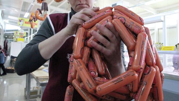 Продавец раскладывает товар в колбасном отделе Продавец раскладывает товар в колбасном отделе