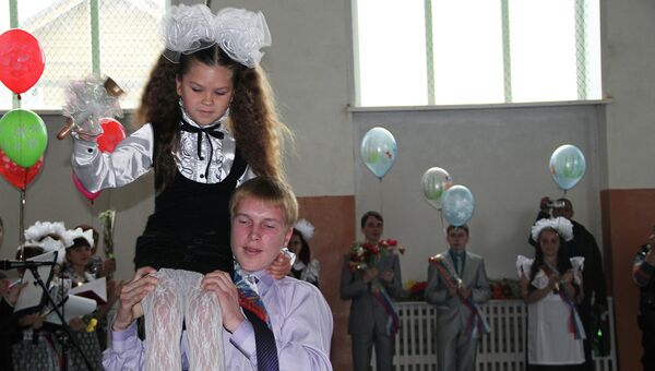 Школа села Майма (Республика Алтай). Выпускник несет на плечах первоклассницу Школа села Майма (Республика Алтай). Выпускник несет на плечах первоклассницу