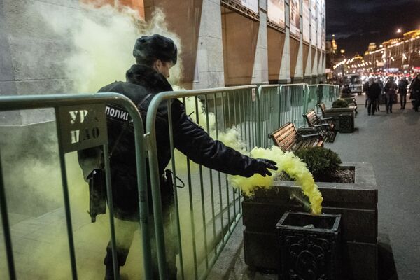 Сотрудник правоохранительных органов выбрасывает файер в урну во время акции Стратегия-31 Сотрудник правоохранительных органов выбрасывает файер в урну во время акции Стратегия-31