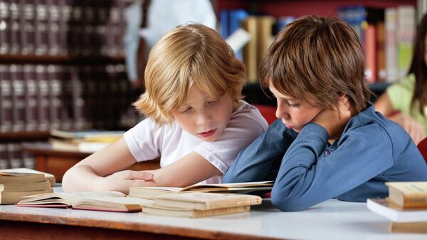 Школьники читают книги в библиотеке Школьники читают книги в библиотеке
