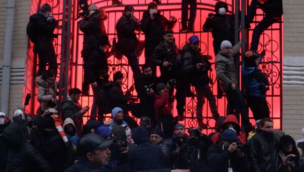 Люди залезают на ворота недалеко от здания администрации президента Украины Люди залезают на ворота недалеко от здания администрации президента Украины
