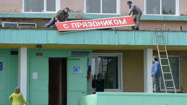 Демонтаж плаката С праздником на Доме культуры в поселке Ключи Камчатского края. Демонтаж плаката С праздником на Доме культуры в поселке Ключи Камчатского края.