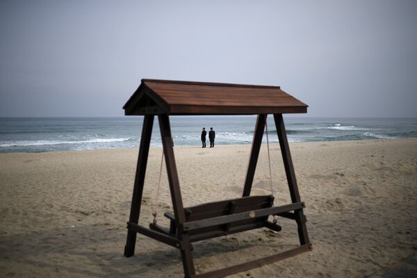 Мужчины в деловых костюмах на пляже Gyeongpo Beach в городе Каннын, Республика Корея Мужчины в деловых костюмах на пляже Gyeongpo Beach в городе Каннын, Республика Корея